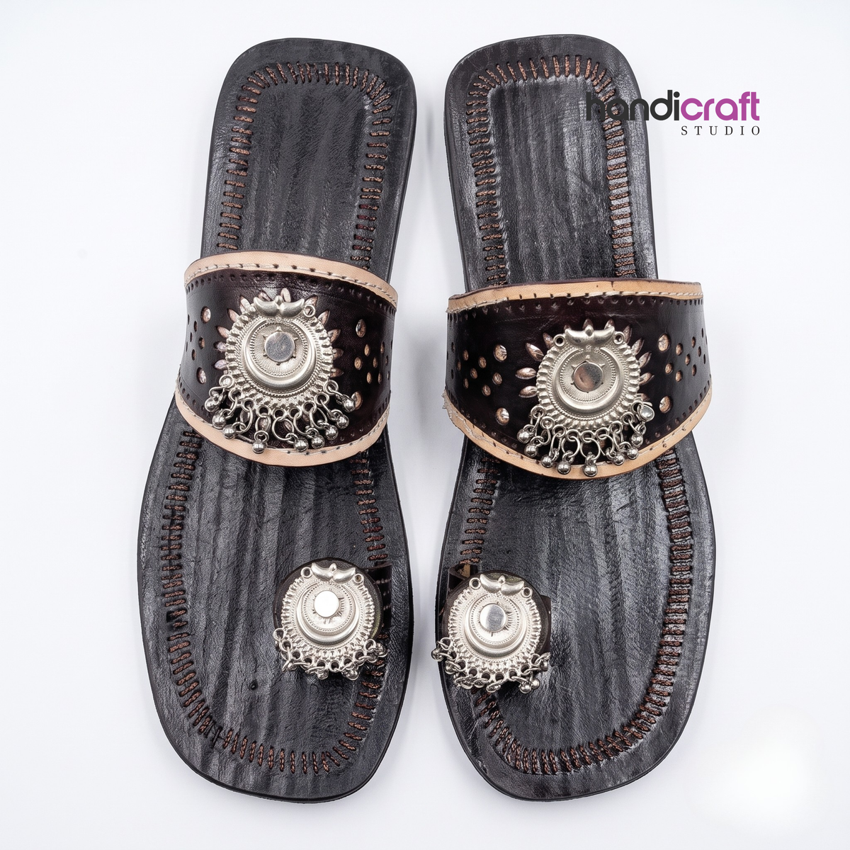 A pair of dark brown leather slide sandals with intricate silver-toned metal toe rings and decorative straps, displayed on a clean white background with a 'landicraft STUDIO' watermark in the top right.