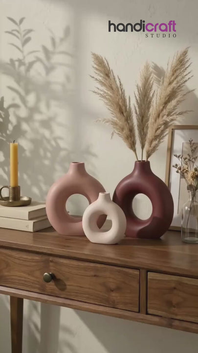 Small ceramic donut vase sitting neatly on a tidy work desk beside stationery