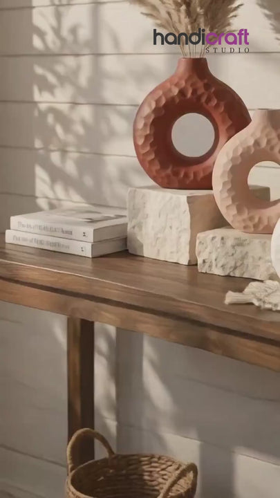 Donut vase ceramic piece styled on a hallway console with candles and greenery