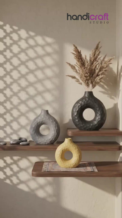 Round donut ceramic vase mounted near a plain wall nook adding shape and interest