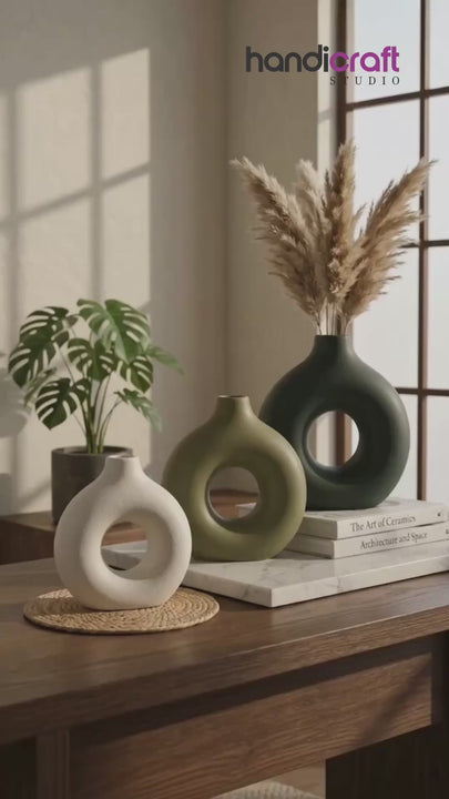 Ceramic vase with a ring shape displayed as an art object on a styled table top