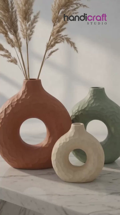 Handmade ceramic donut vase styled on a shelf corner beside books and a small plant
