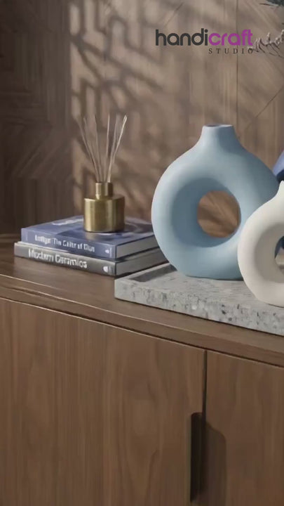 Ceramic vase with a neat circular hollow centre photographed from the front